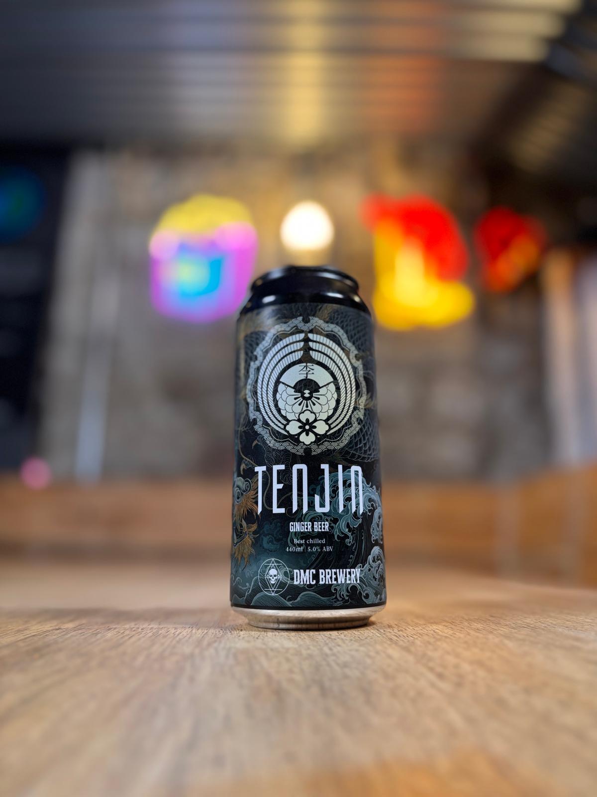 Beer can labeled 'Tenjin' on a wooden surface with a blurred background